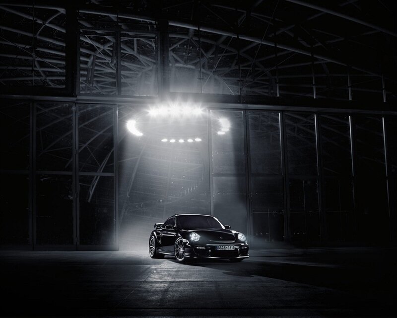 Black Porsche in a dark hangar