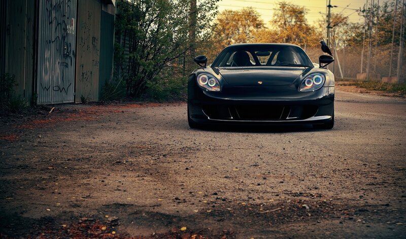 Black Porsche on a dirt road