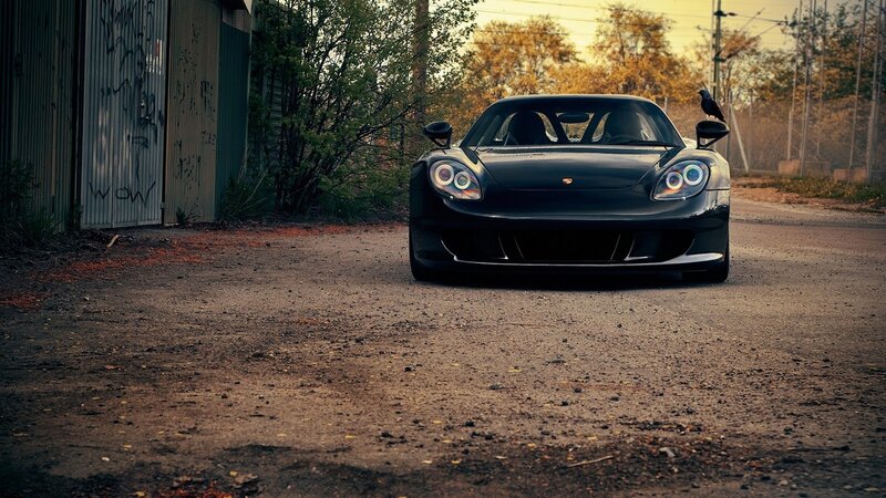Black Porsche on a dirt road