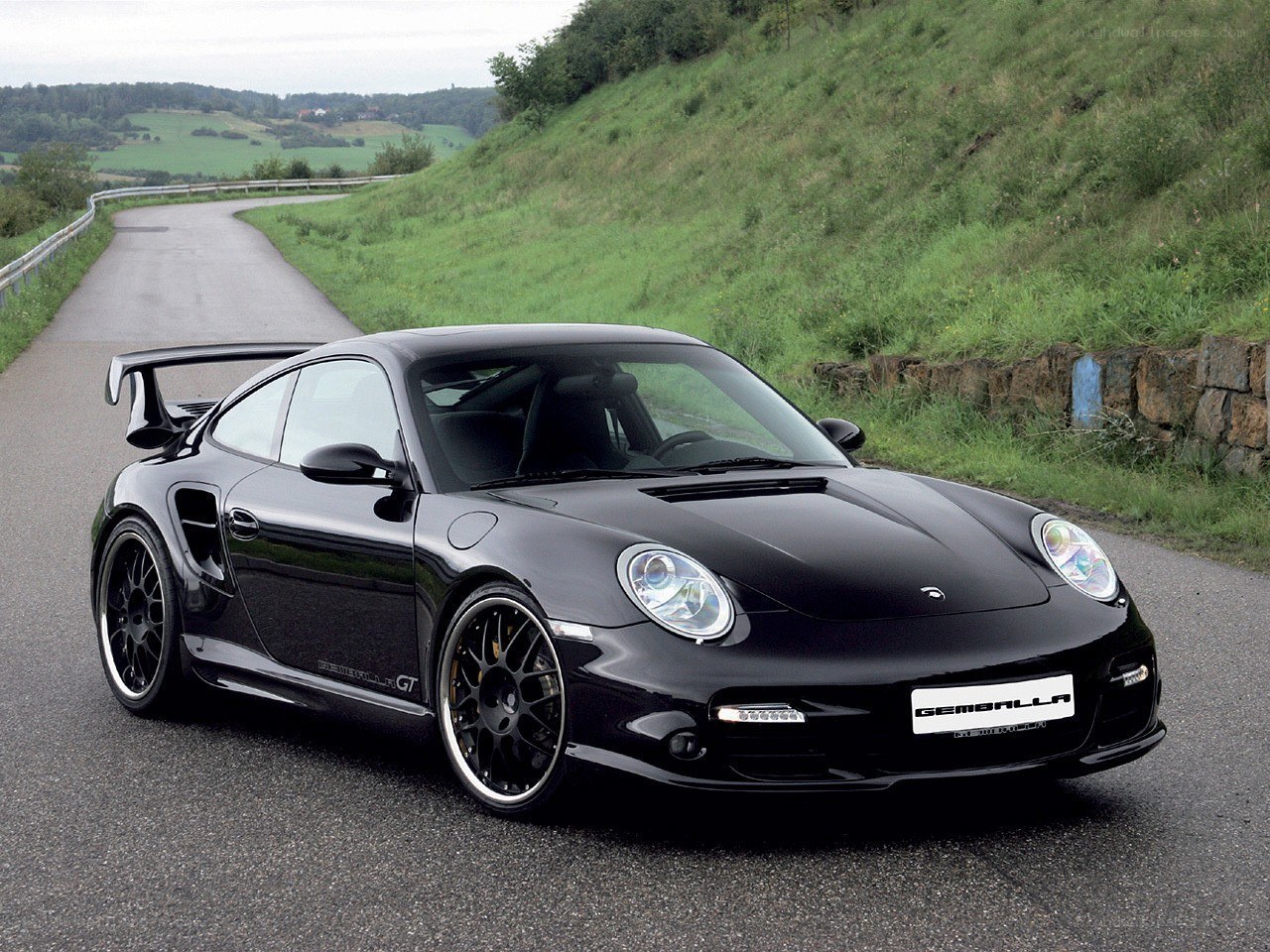 Black Porsche on a winding road