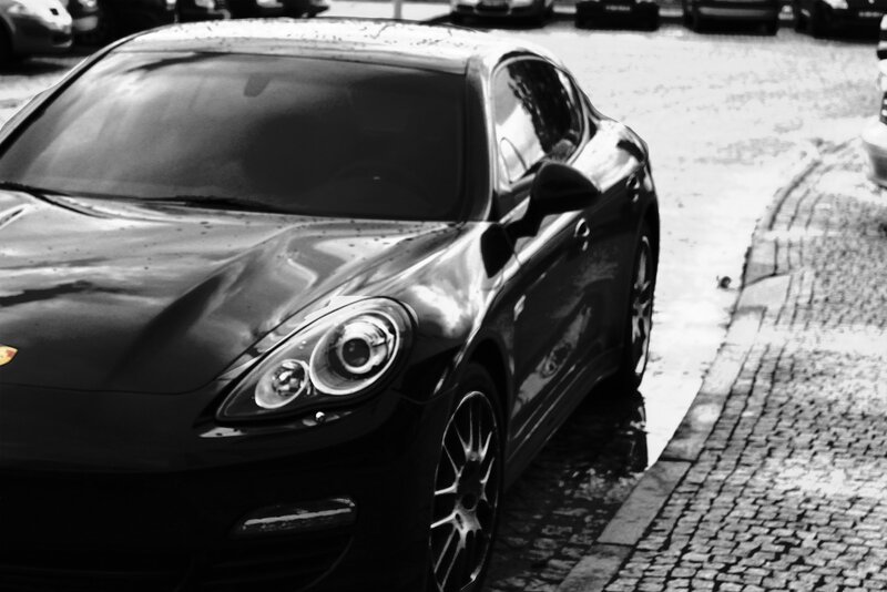 black porsche on cobblestone street