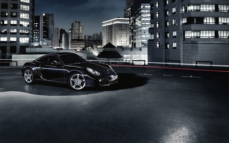 Black Porsche on rooftop at night