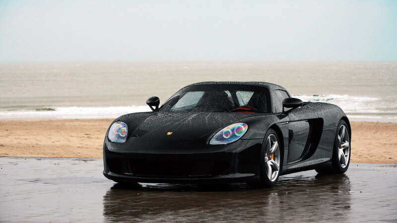 Black Porsche on wet beach
