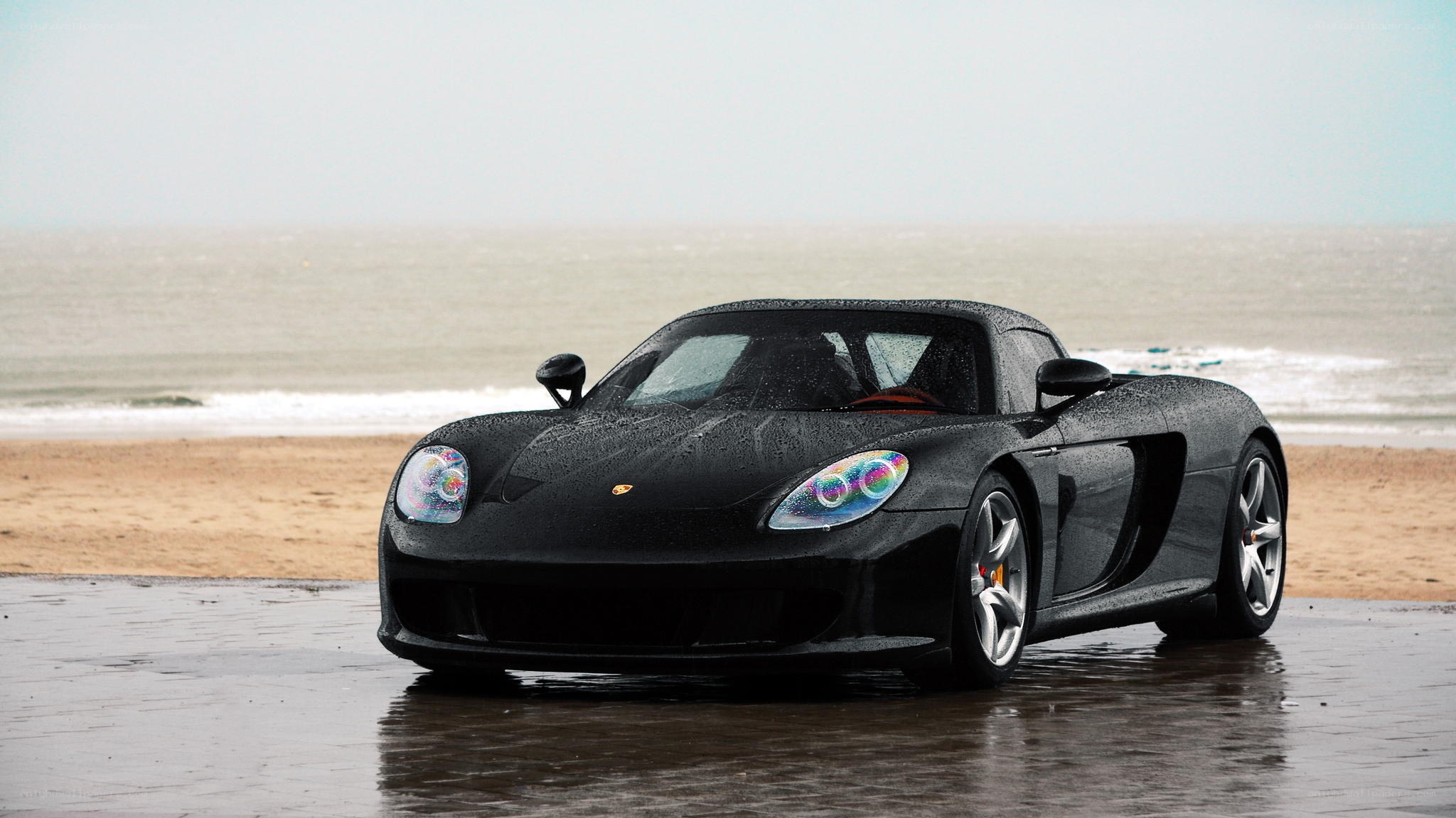 Black Porsche on wet beach