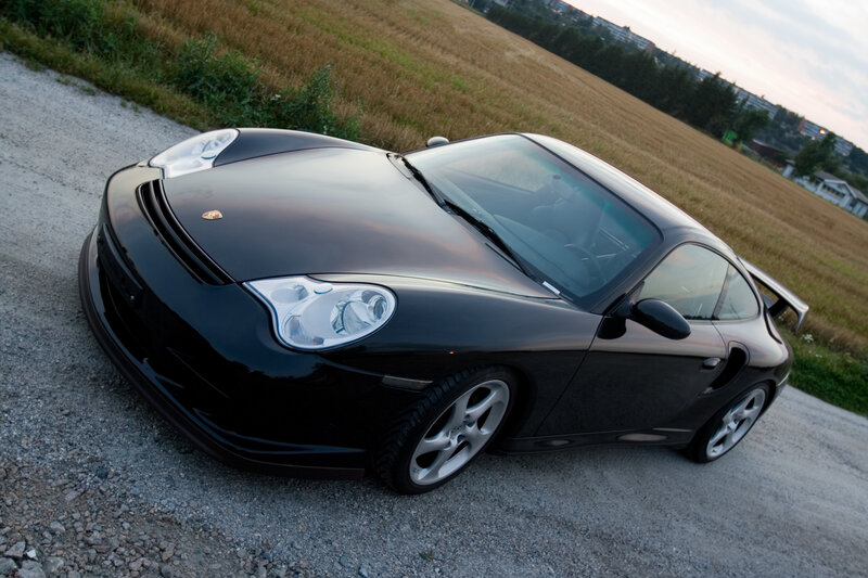 Black Porsche sports car on gravel