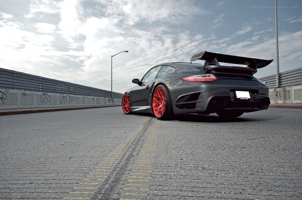 Black Porsche with red wheels