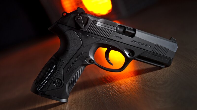 Black PX4 pistol on wooden surface