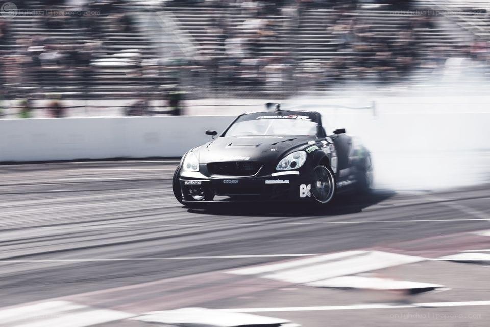 Black race car drifting on track