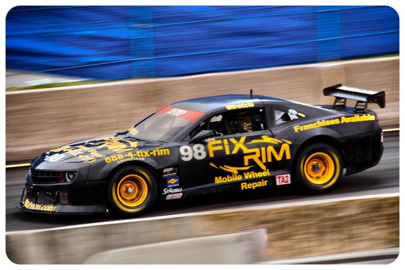 Black Race Car — Dynamic, Afternoon, Photograph, Race Track, Driver, Tire, Yellow