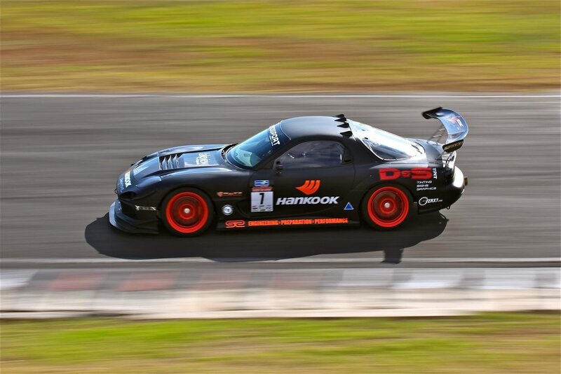 Black Race Car on Track — Dynamic, Afternoon, Photograph, Race Car, Grass, Red