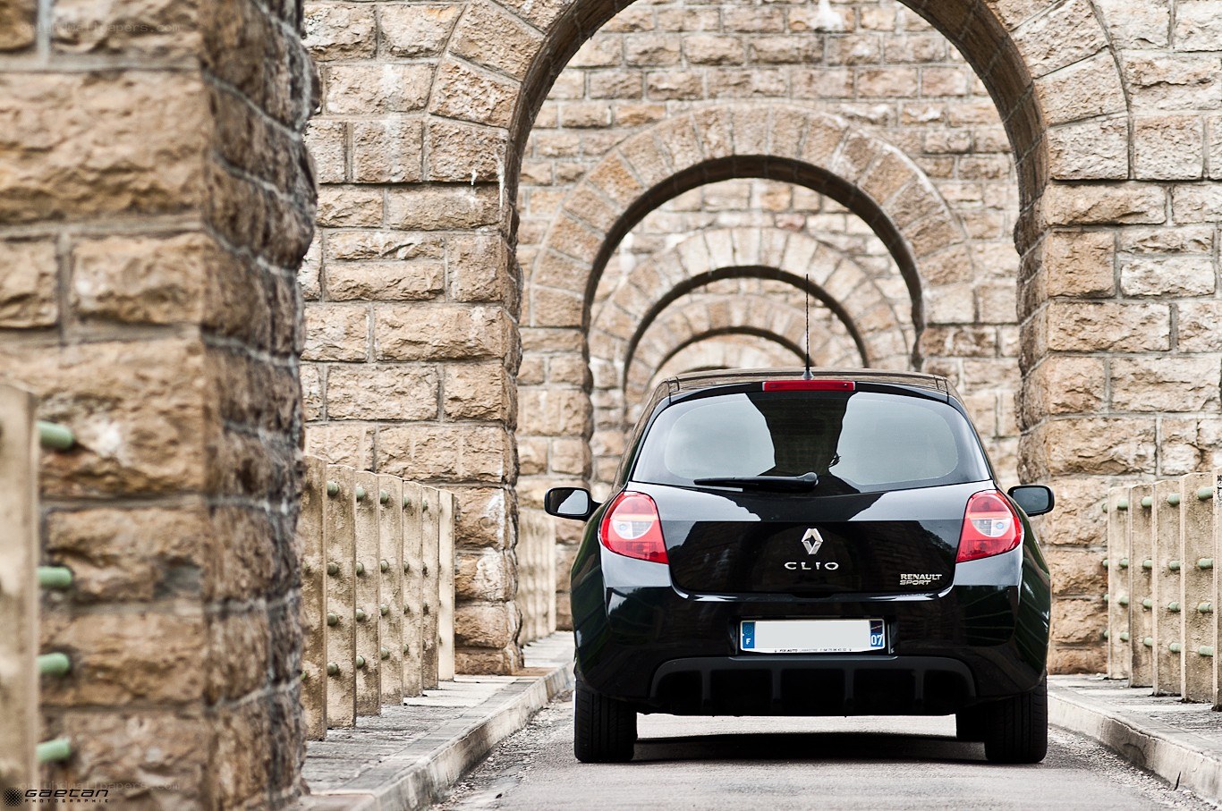 Black Renault Clio under stone arches