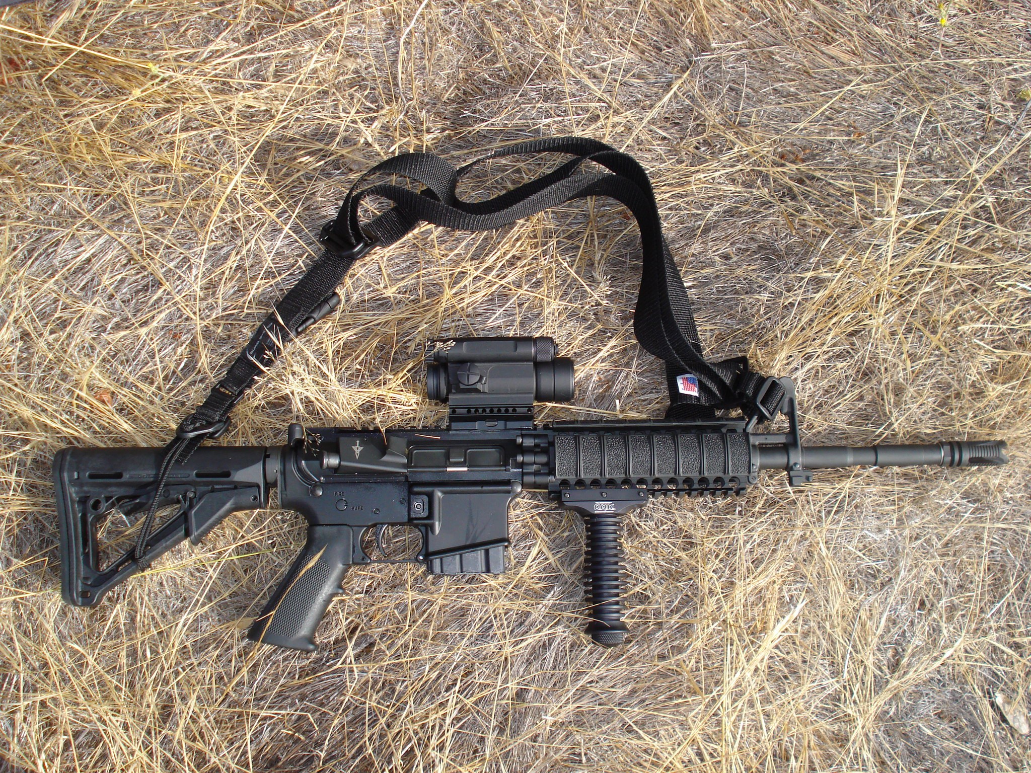 black rifle on dry grass