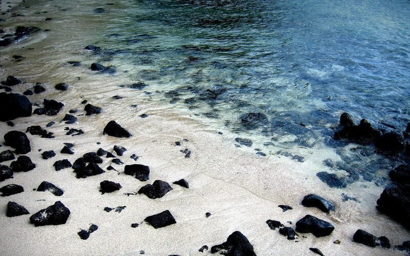 Black Rocks on Sandy Beach — Blue