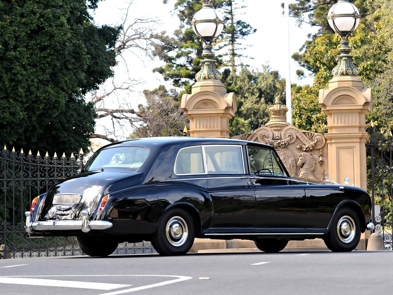 Black Rolls-Royce at ornate gate