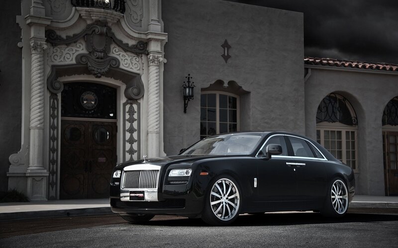 Black Rolls-Royce in front of mansion