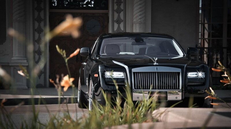 Black Rolls-Royce in front of mansion