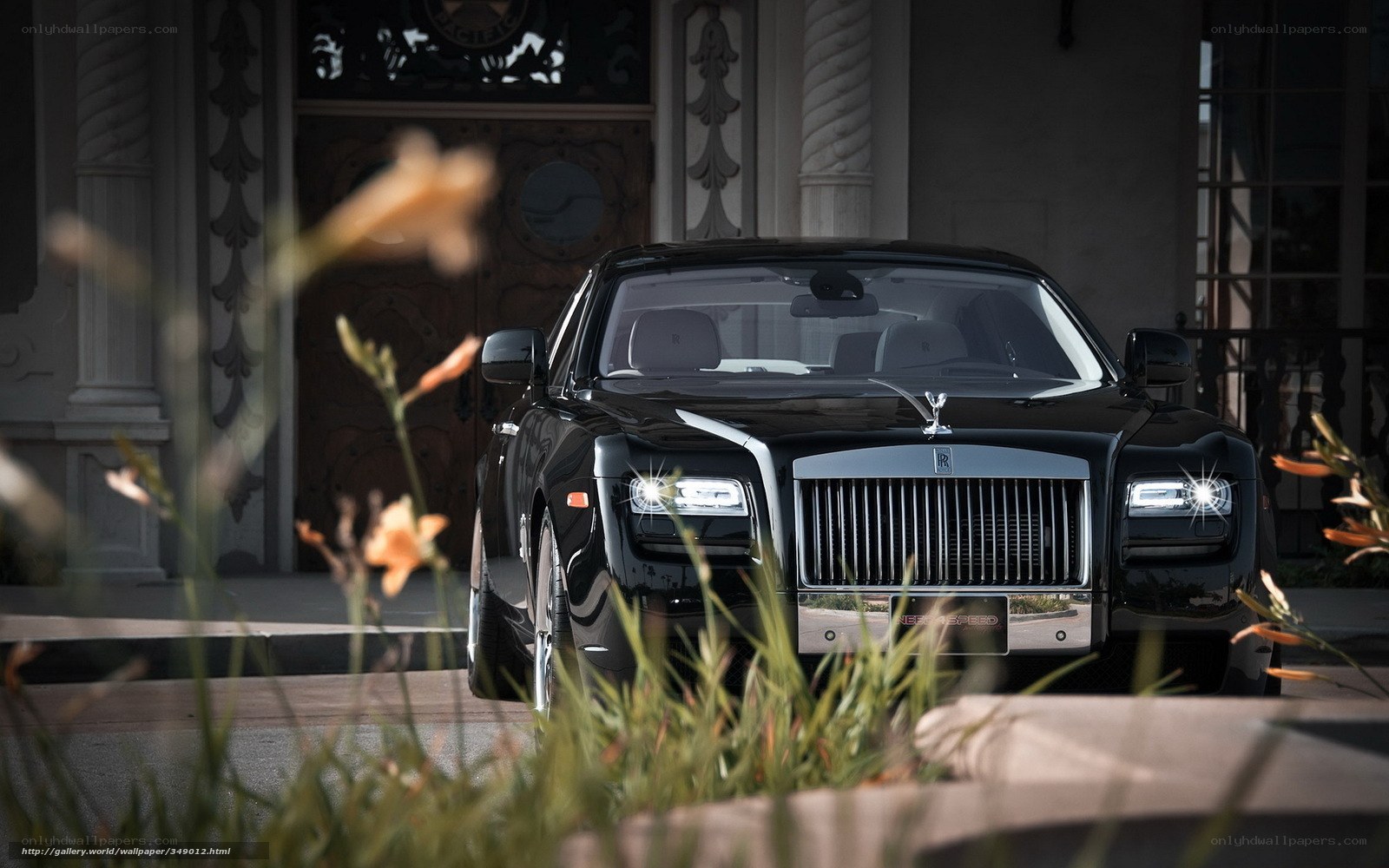Black Rolls-Royce in front of mansion
