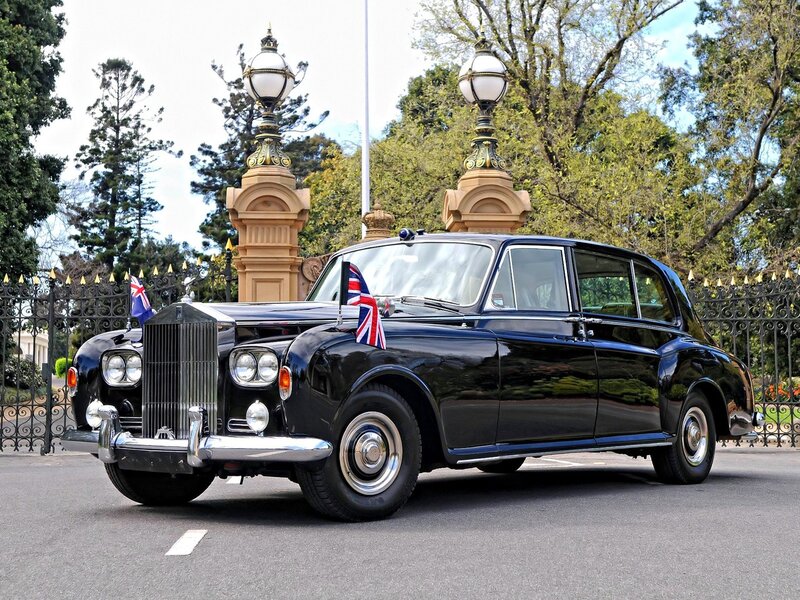 Black Rolls-Royce with flags