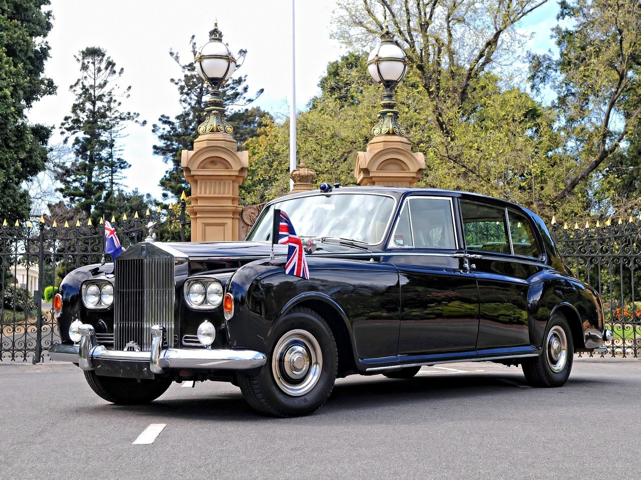 Black Rolls-Royce with flags