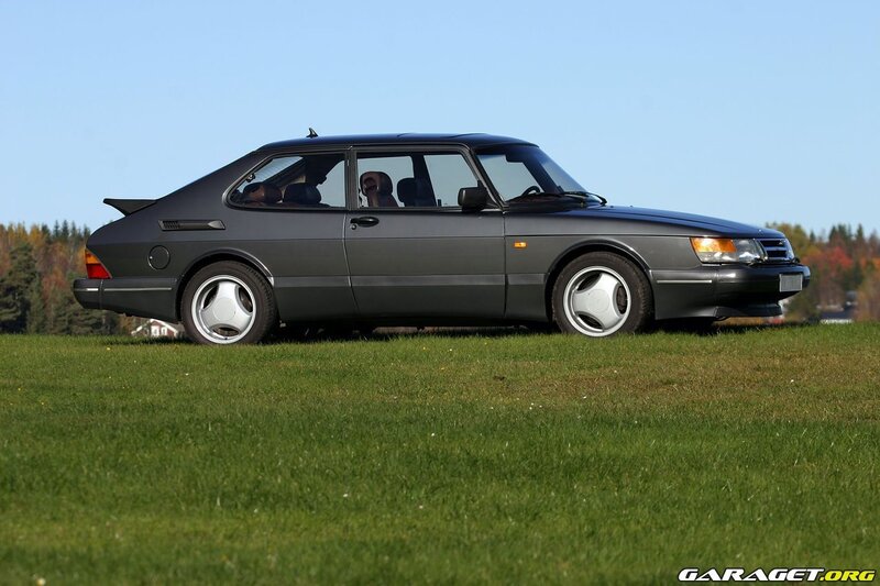 Black Saab 9000 on a grassy field