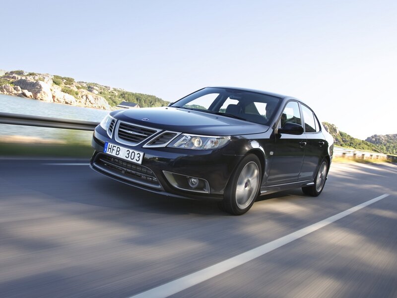 Black Saab sedan on coastal road