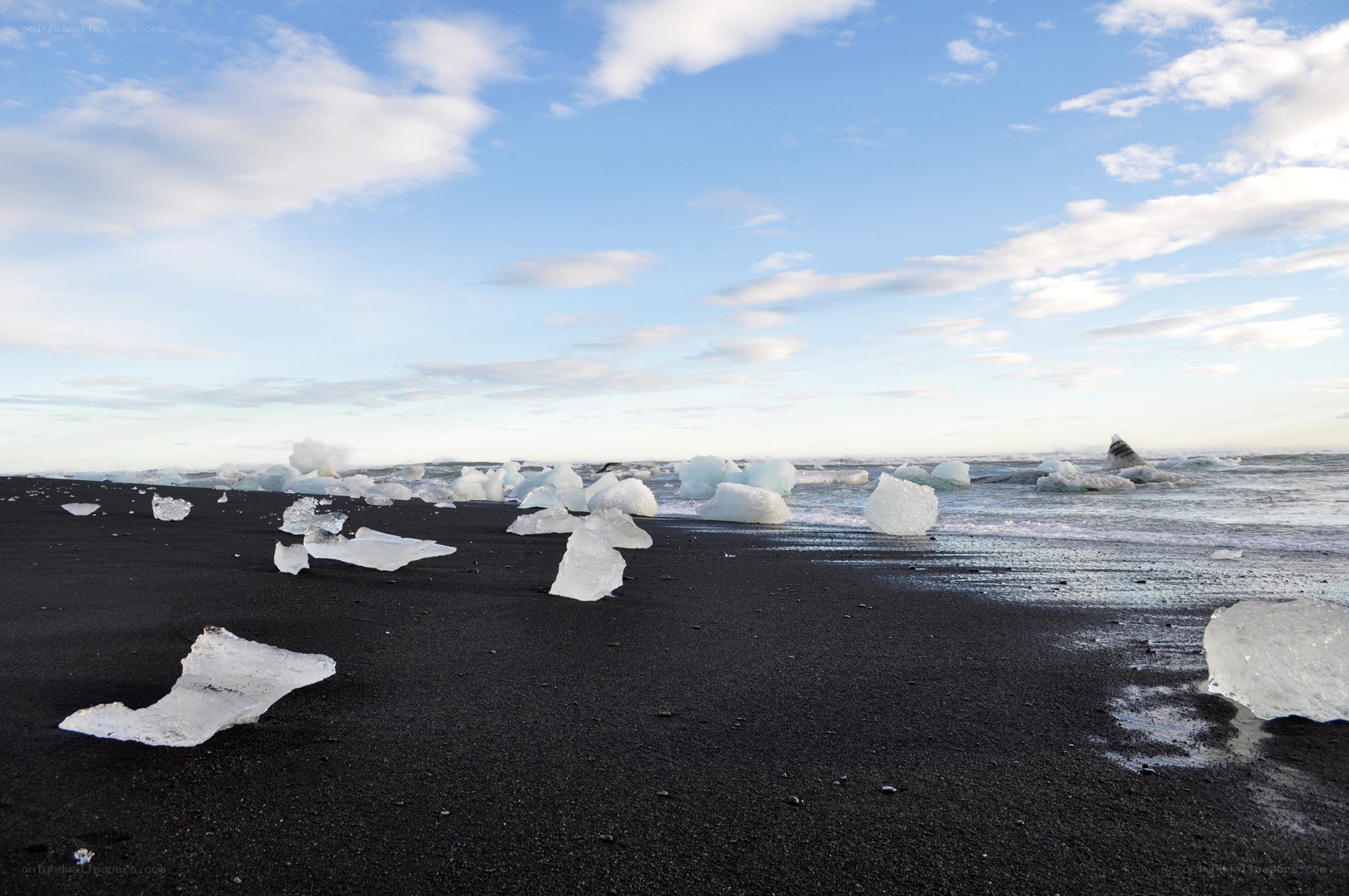 Black sand beach with icebergs