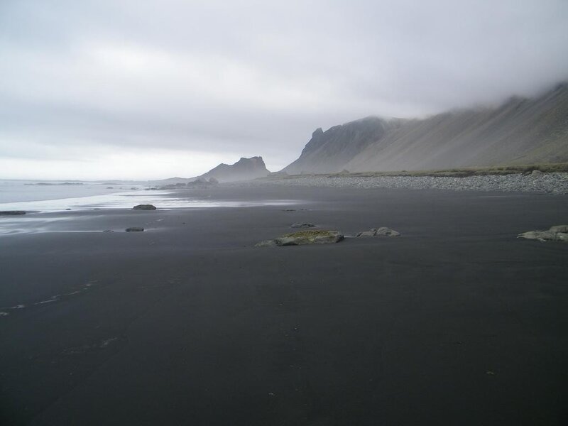 black sand beach with mountains
