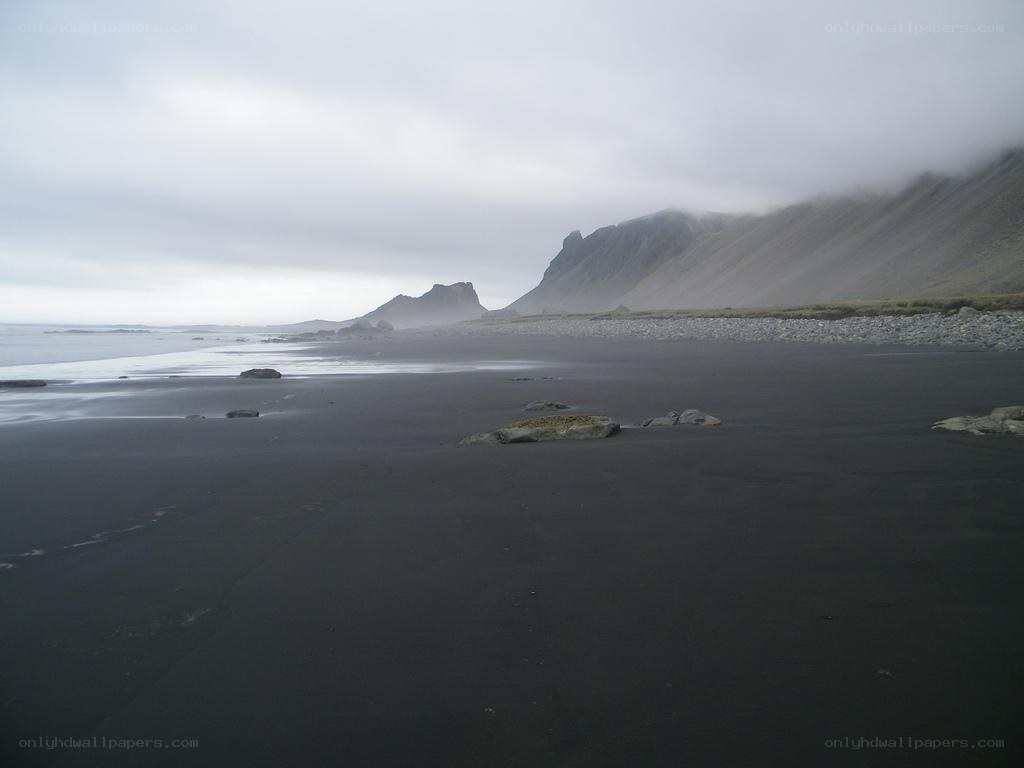 black sand beach with mountains
