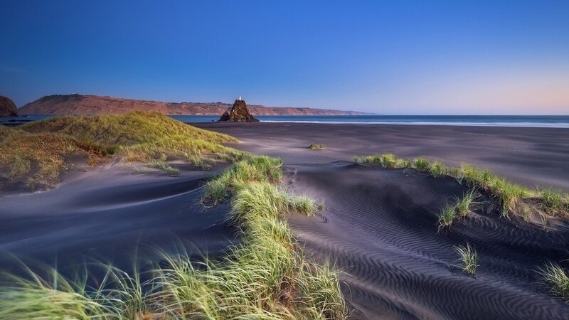 Black sand beach with sea stack