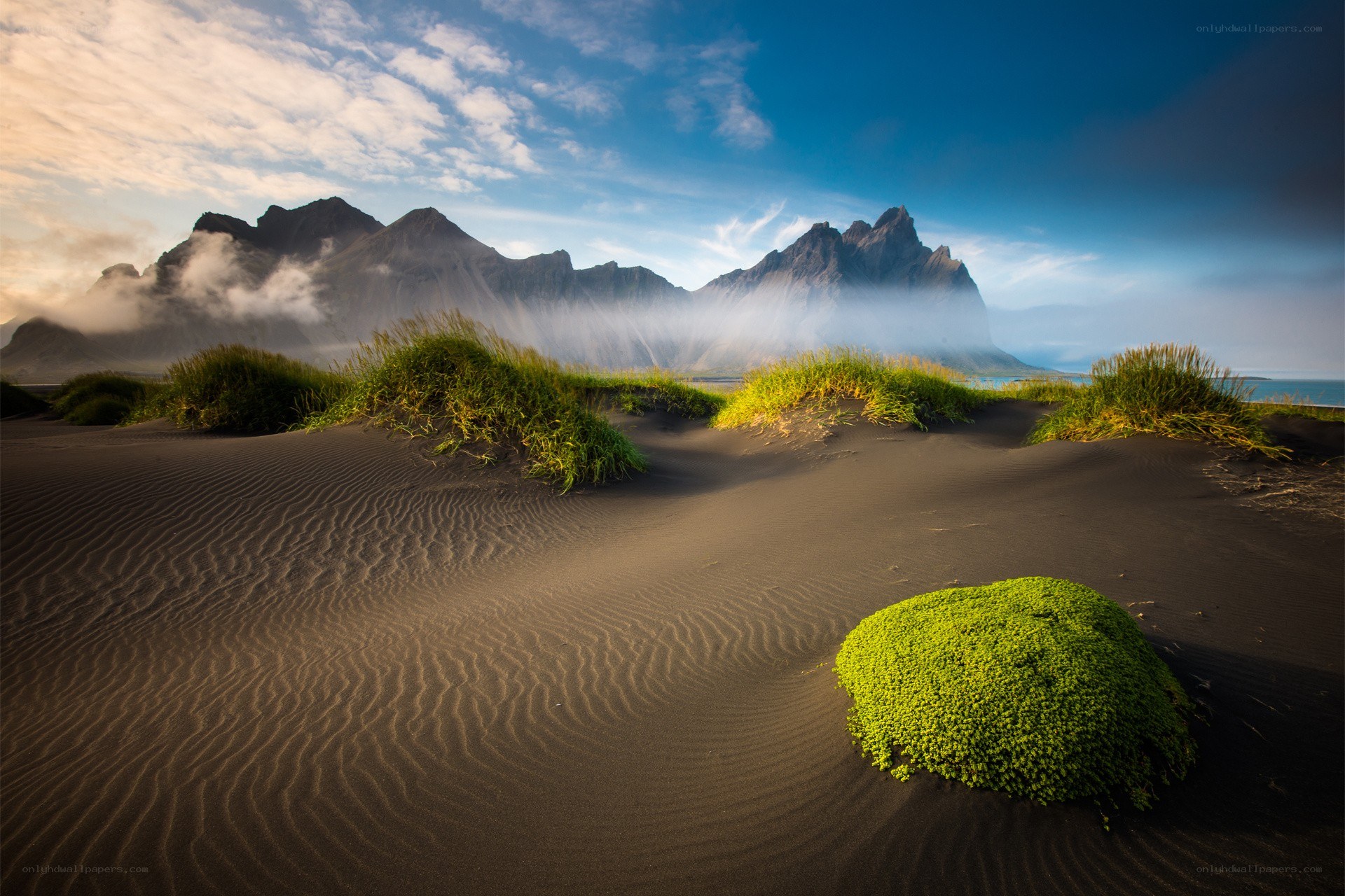 Black sand dunes with mountains