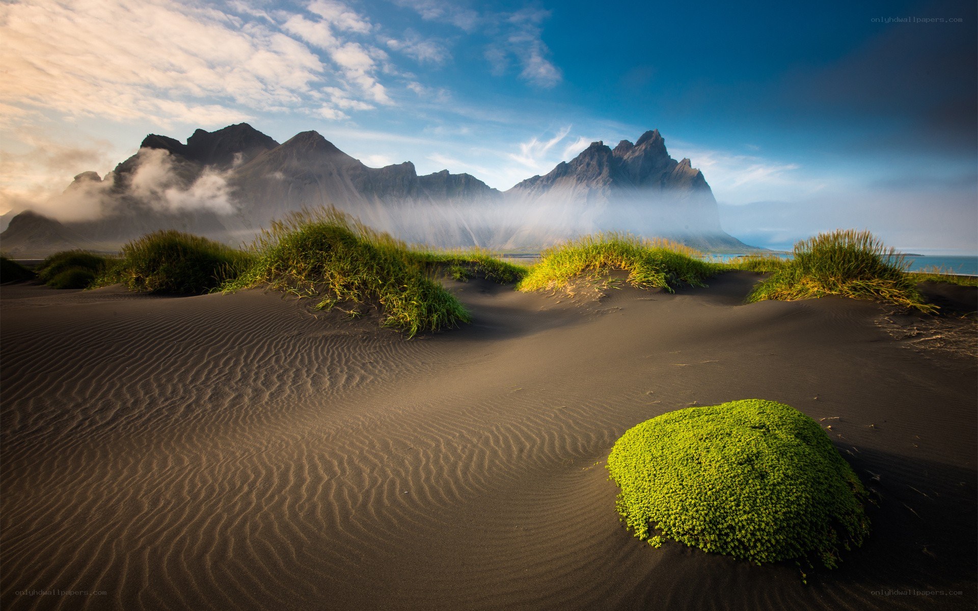 Black sand dunes with mountains