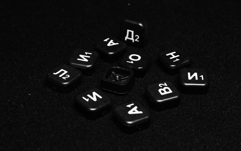 Black Scrabble tiles on dark surface