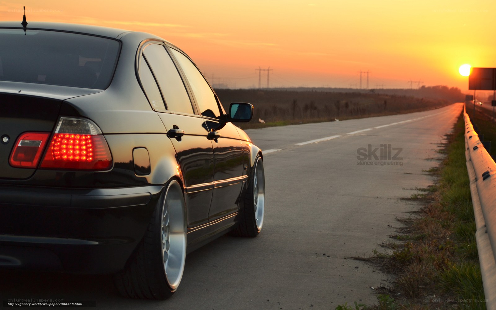 Black sedan at sunset on road