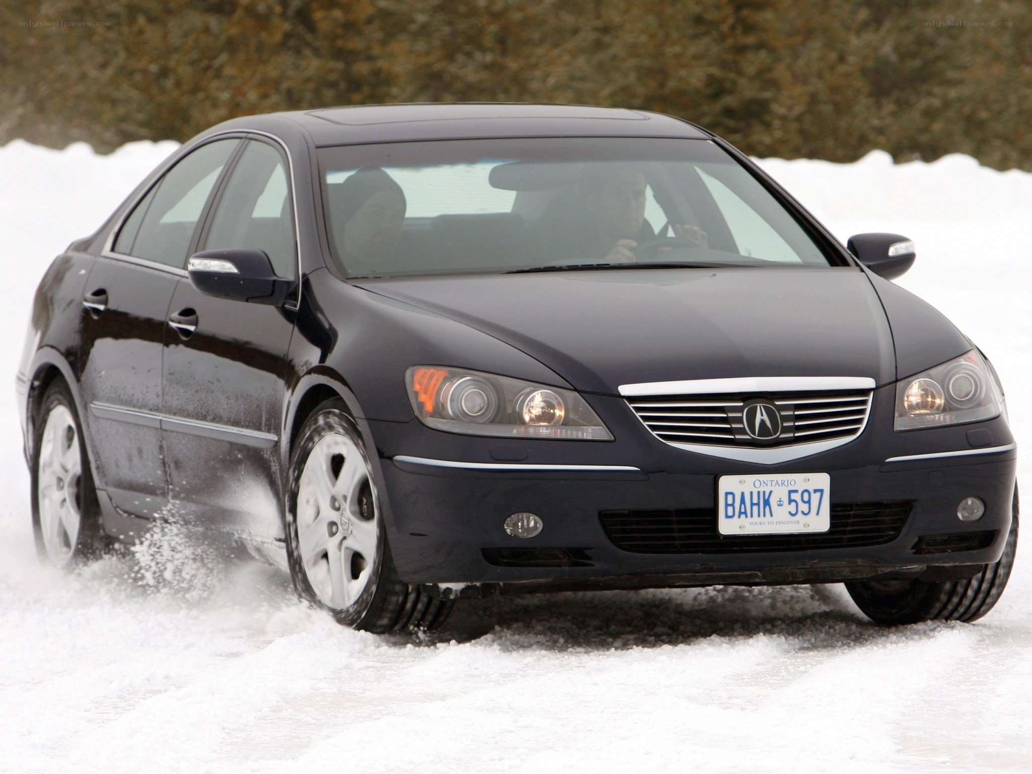 Black sedan driving in snow
