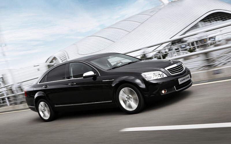 Black sedan driving on a bridge