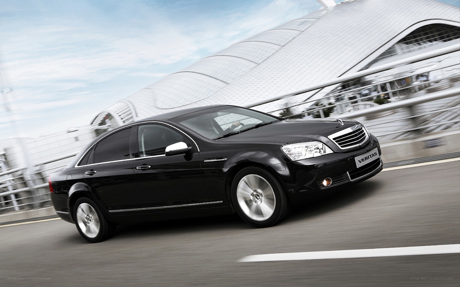 Black sedan driving on a bridge