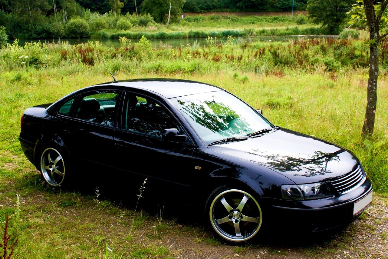 Black sedan in a grassy field