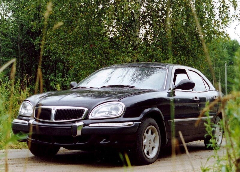black sedan in a wooded area