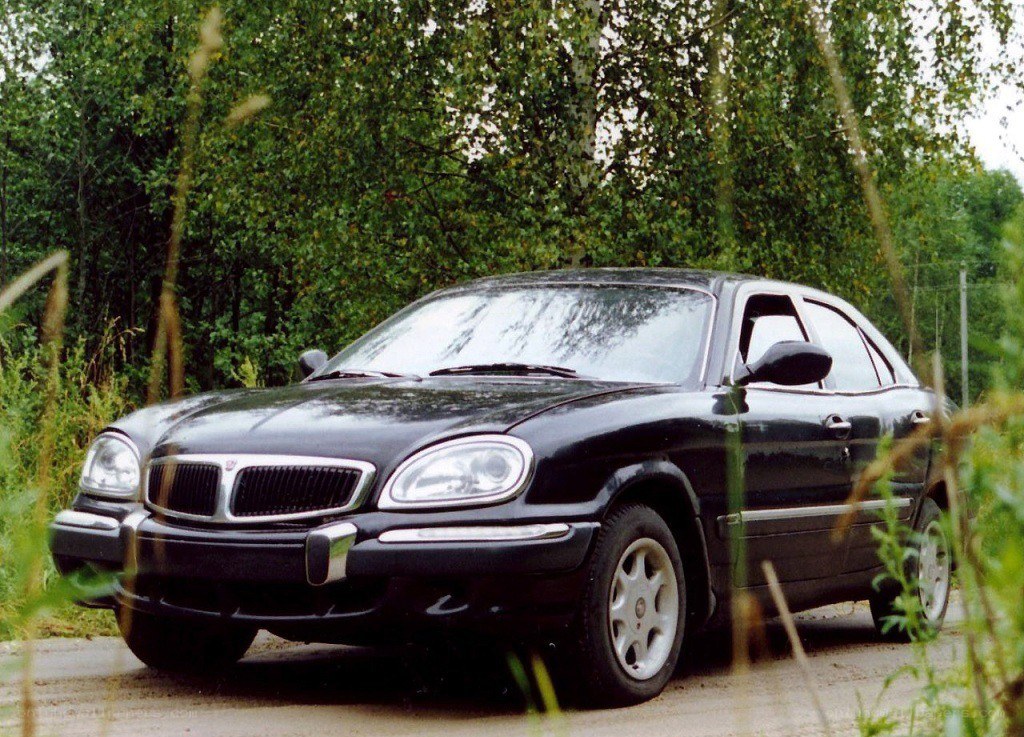 black sedan in a wooded area