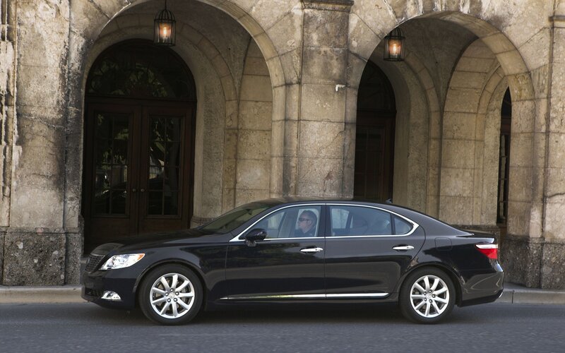 Black sedan in front of stone building