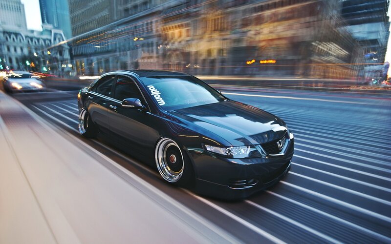 Black sedan in motion on city street