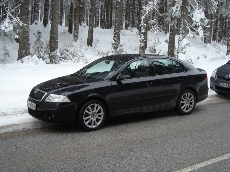 Black sedan in snowy forest
