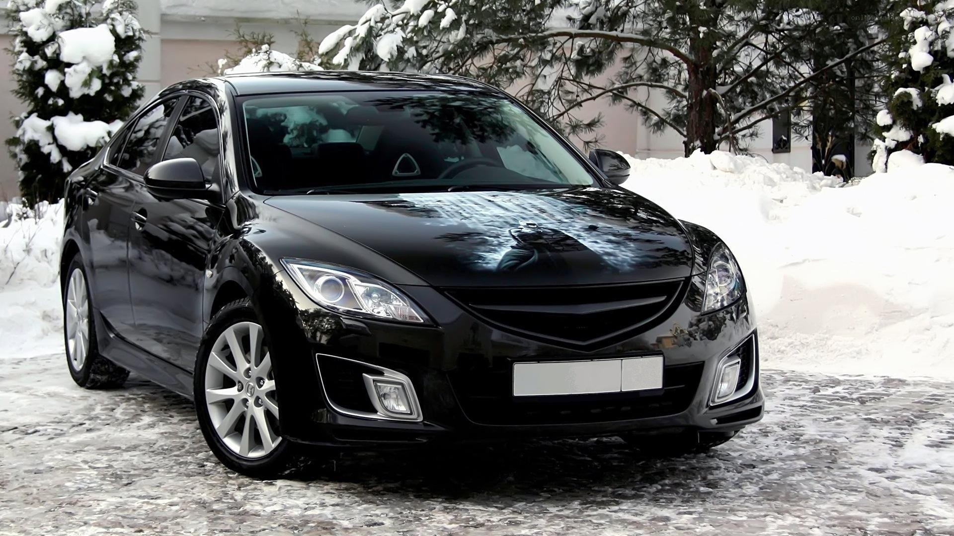 Black sedan in snowy landscape