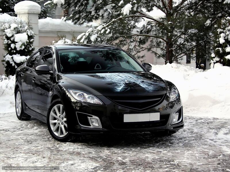 Black sedan in snowy landscape