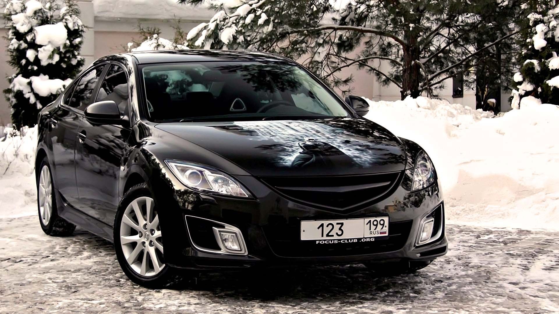 Black sedan in snowy setting