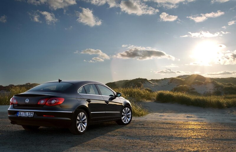 Black sedan on a sandy path