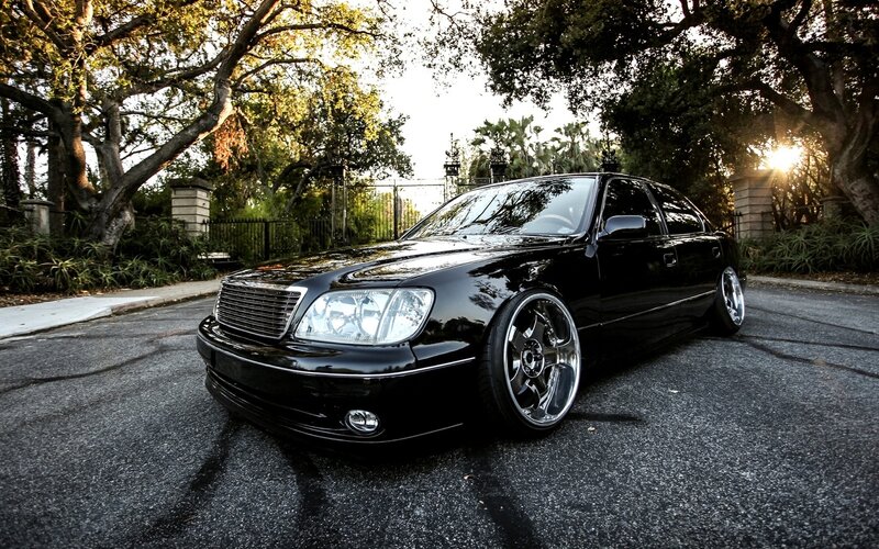 black sedan on a tree-lined street
