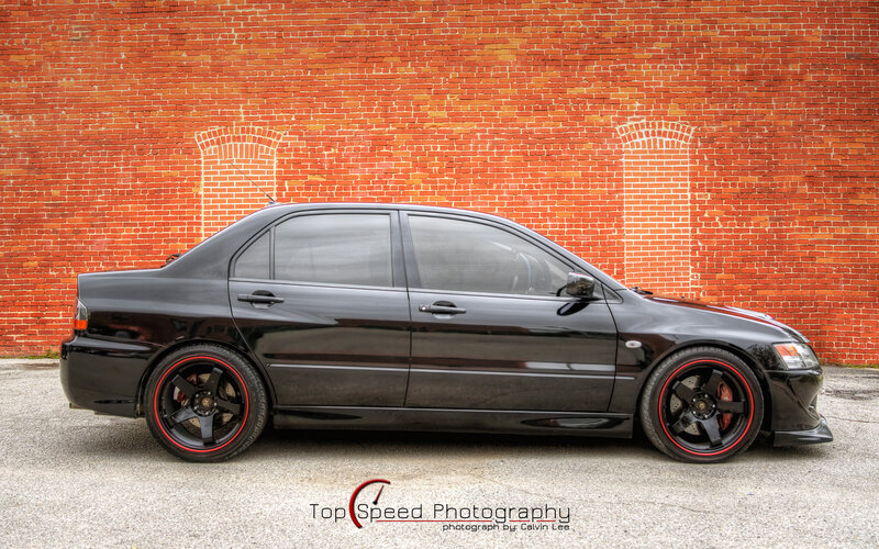 black sedan on brick wall