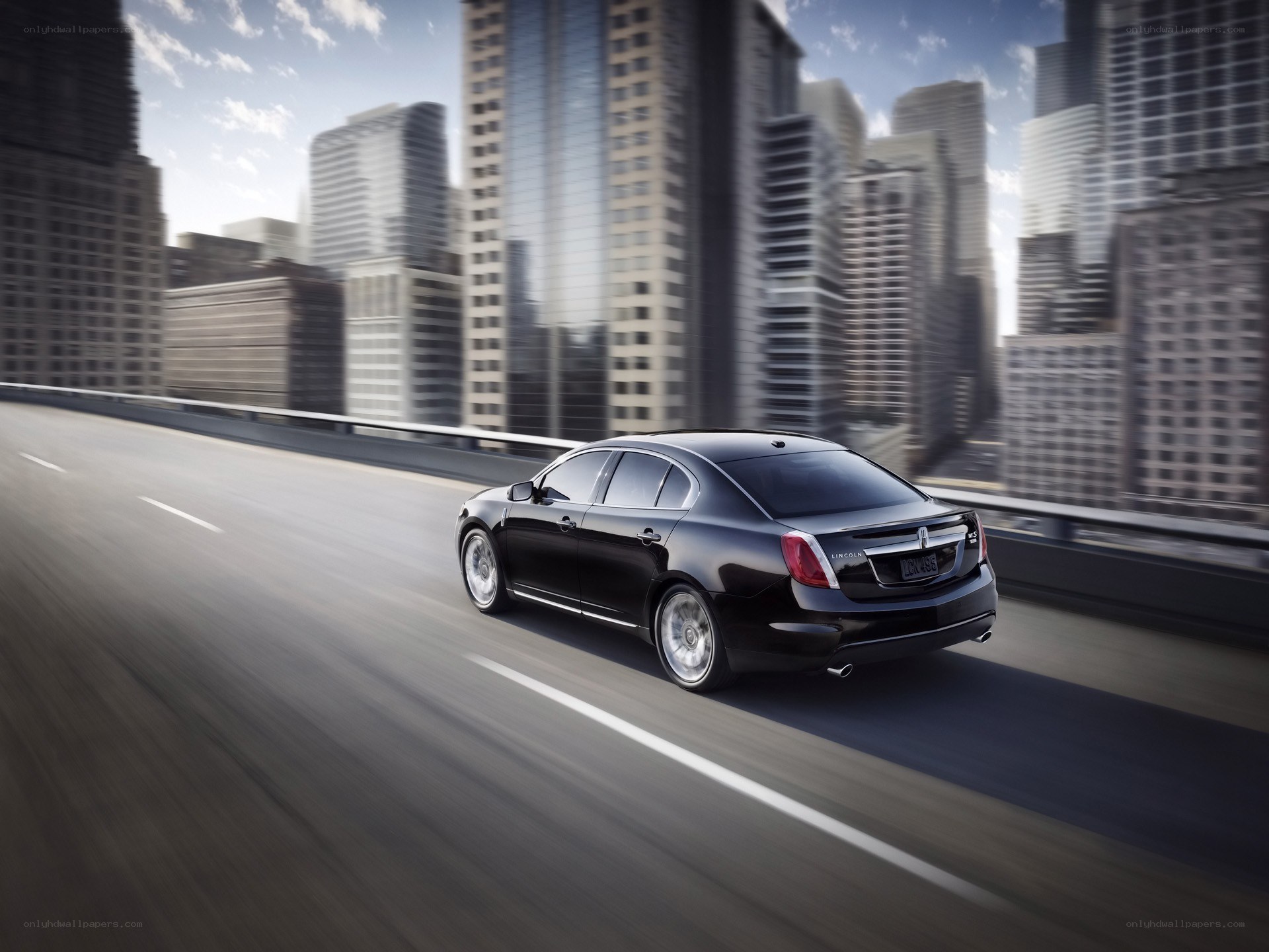 Black sedan on city highway