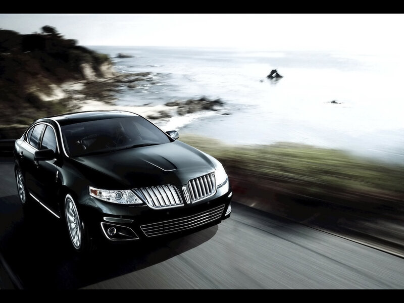 Black sedan on coastal road
